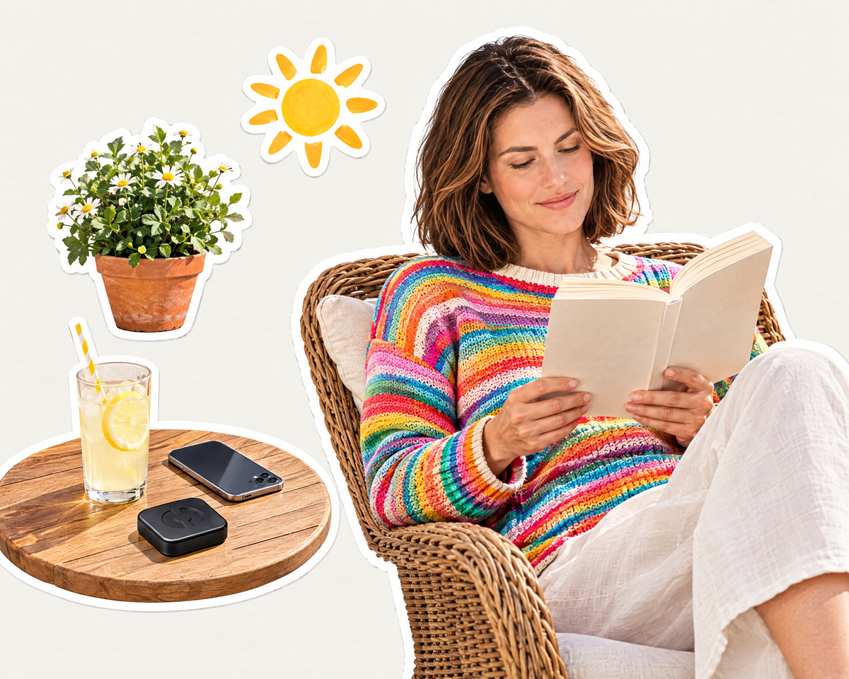 Vrouw leest in de zon, telefoon en Phase op tafel