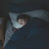 Iemand ligt 's nachts in bed op haar telefoon